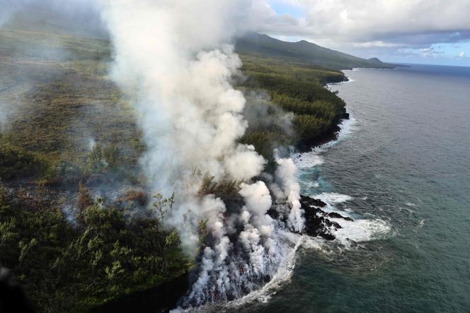 De la fumée s’élevant de la lave du piton de la Fournaise atteignant l’océan à Sainte-Rose (La Réunion), le 16 mars 2026. 