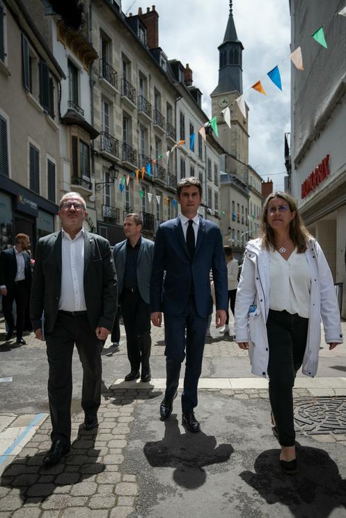 O prefeito de Nevers, Denis Thuriot, o então primeiro-ministro, Gabriel Attal (centro), durante uma visita de campanha para apoiar Perrine Goulet (à direita), candidato da coalizão de direita Ensemble nas eleições legislativas, em Nevers, 4 de julho de 2024.