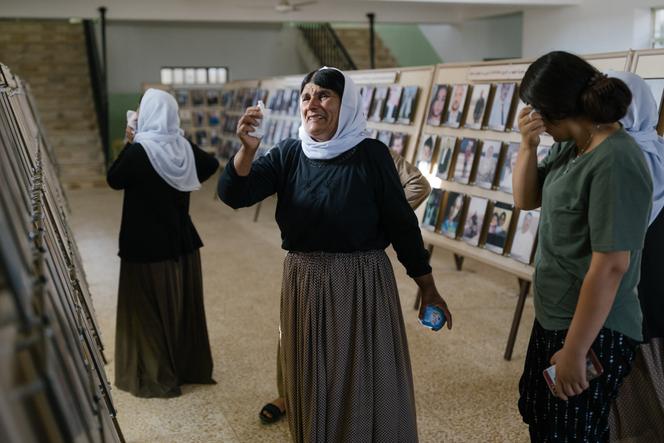 Des yézidies devant les photos des membres de leur famille tués par l’organisation Etat islamique, dans une école transformée en mémorial, à Kocho (Irak), le 3 août 2021. 