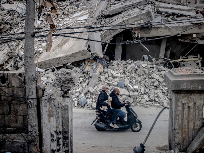 Des habitants de Beyrouth passent devant un immeuble détruit par une frappe israélienne, le 18 mars 2026.