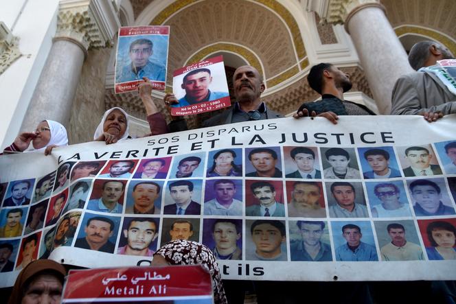Un rassemblement de SOS disparus, derrière une banderole montrant des portraits de disparus de la « décennie noire » (1992-2002), à Alger, le 3 avril 2019.