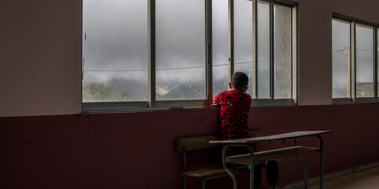 Un enfant déplacé de Khiam regarde à la fenêtre d’une école qui accueille plusieurs familles de déplacés internes, à Hasbaya, le 20 mars 2026.