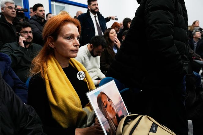A woman holds a portrait of her cousin, a victim of the Tempi train crash, at court in Larissa, Greece, on Monday, March 23, 2026.