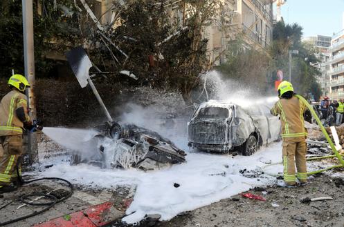 Des pompiers israéliens sur le site d’une frappe de missile iranien, à Tel-Aviv (Israël), le 24 mars 2026.