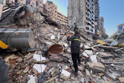 Un agent de la protection civile, devant un immeuble détruit par une frappe aérienne israélienne, dans la banlieue sud de Beyrouth, le 24 mars 2026.
