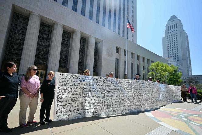 Des parents brandissent une banderole énumérant les noms de jeunes qui se sont suicidés, devant le tribunal de Los Angeles, à l’issue du procès contre Meta et Google, le 25 mars 2026.