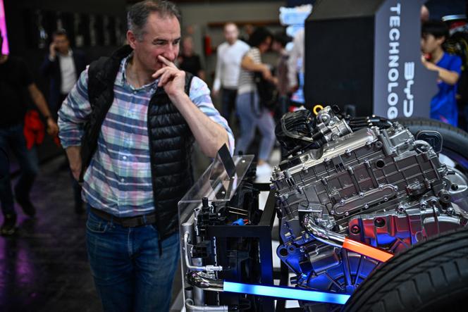 Un visiteur observe le moteur électrique BYD Super DM au Mondial de l’automobile de Paris, à Paris Expo Porte de Versailles, le 16 octobre 2024.