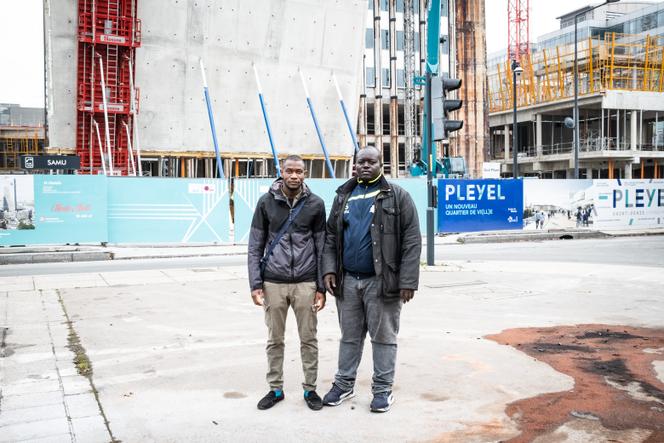 Daouda Tounkare et Cheikna Sarambounou, ouvriers du bâtiment, devant le chantier de la Tour Pleyel à Saint-Denis (Seine-Saint-Denis), où ils ont travaillé plusieurs mois sans papiers, le 29 novembre 2022.