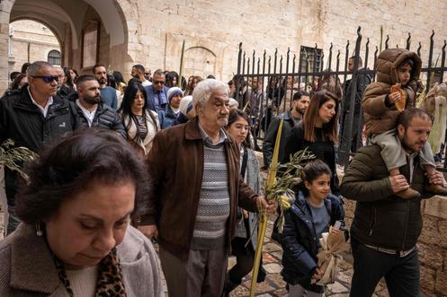 Des catholiques entament la procession de la messe des Rameaux, au monastère franciscain Saint-Sauveur, à Jérusalem, le 29 mars 2026.