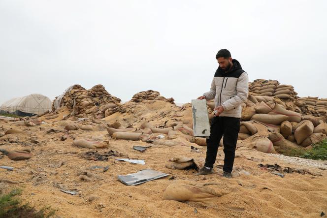 Un homme inspecte les décombres d’un entrepôt de blé détruit par des drones, près de la base américaine de Qasrak, dans la campagne de Hassaké, en Syrie, le 29 mars 2026.