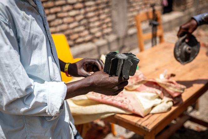 Moradores examinam estilhaços de munições que danificaram uma escola em 1º de abril de 2026, após explosões em um incêndio em um arsenal militar no distrito de Musaga, em Bujumbura.