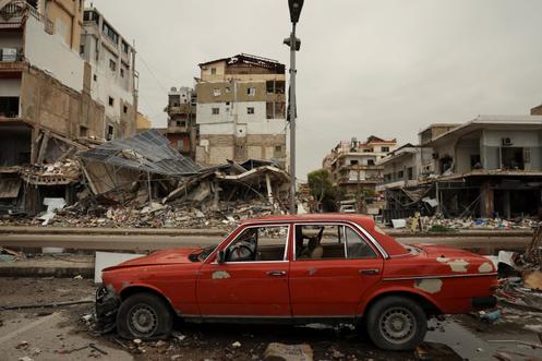 Une voiture endommagée, devant les décombres d’un immeuble détruit par une frappe israélienne, à Tyr (Liban), le 2 avril 2026.