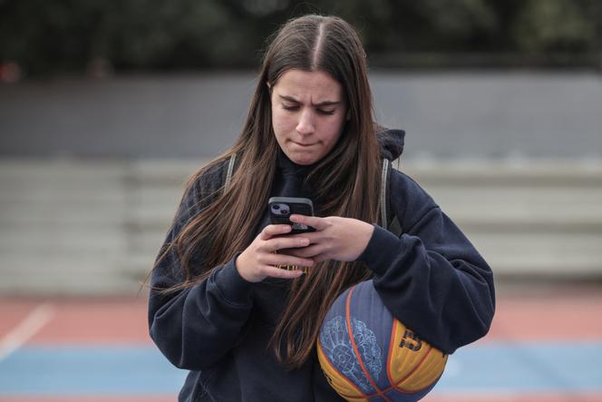 Catherine Daniil, 14 anos, ao telefone em Atenas, 26 de fevereiro de 2026. 