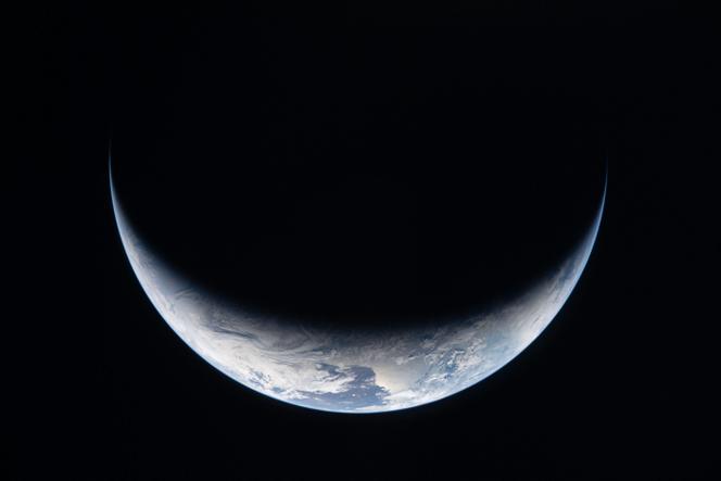 Uma grande parte da Terra mergulhou na escuridão, vista através da vigia da espaçonave Orion, em 3 de abril de 2026.