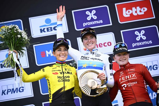 Demi Vollering (centro), cercada por Pauline Ferrand-Prévot (esquerda) e Puck Pieterse, no pódio do Tour de Flandres em Oudenaarde (Bélgica), 5 de abril de 2026.  