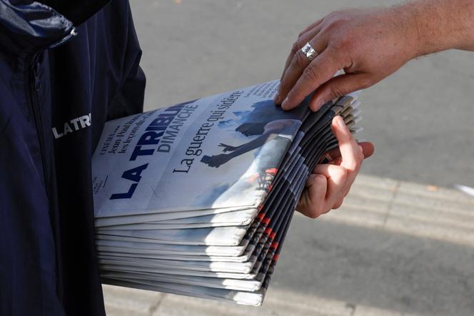 Vendedor ambulante distribuindo “La Tribune Dimanche”, em Paris, em outubro de 2023.