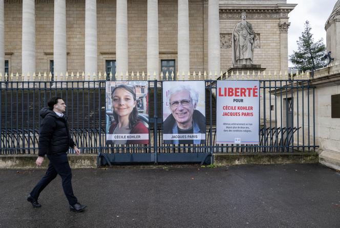 Os retratos de Cécile Kohler e Jacques Paris expostos na grelha da Assembleia Nacional, em Paris, 11 de março de 2026.