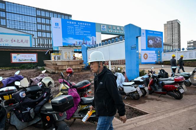 Des ouvriers du bâtiment travaillent sur le site du nouveau siège social du Groupe des terres rares de Chine, à Ganzhou, le 21 novembre 2025.