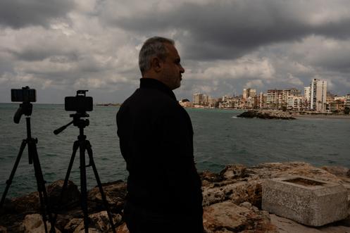 Un journaliste attend de filmer les frappes annoncées par les israéliens, depuis un hôtel de Tyr, le 8 avril 2026.