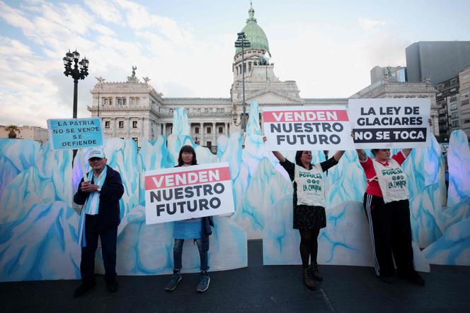 Manifestantes seguram cartazes com os dizeres, em espanhol, “Eles estão vendendo nosso futuro” em frente ao prédio do Congresso durante uma manifestação contra a emenda à lei das geleiras em Buenos Aires, 8 de abril de 2026.