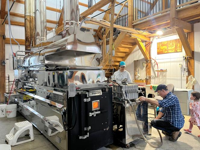 Jean-François Touchette et sa machine à vapeur qui chauffe et concentre l’eau d’érable, extraite de l’arbre, afin de la transformer en sirop, à Saint-Urbain-Premier (Canada), le 31 mars 2026.