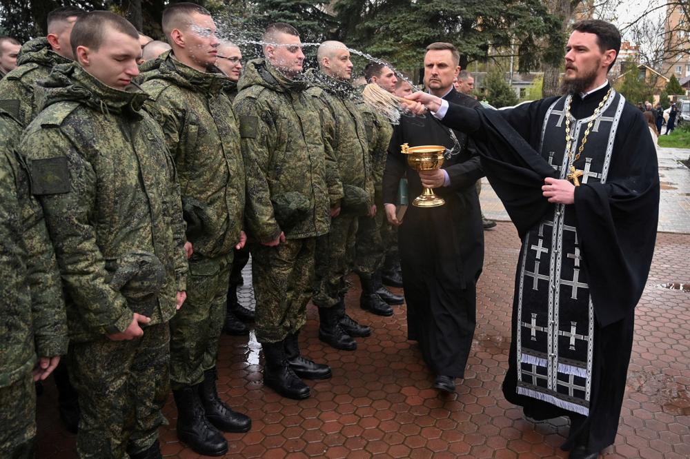 Un prêtre orthodoxe bénit des conscrits russes, à Bataïsk (Russie), le 10 avril 2026. - SERGEY PIVOVAROV/REUTERS
