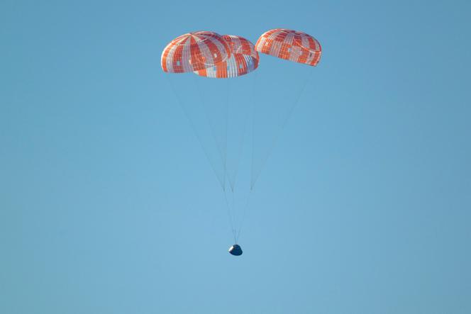 A espaçonave Orion, desacelerada por seus três paraquedas, prepara-se para tocar a superfície do Oceano Pacífico, na costa da Califórnia, em 10 de abril de 2026.