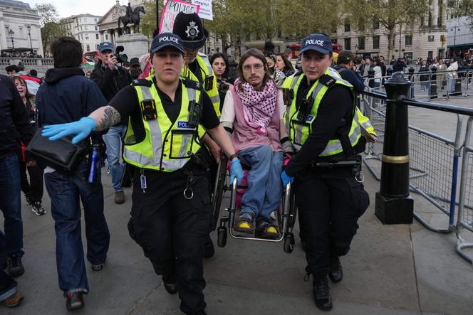 A polícia remove um manifestante enquanto as pessoas se reúnem para exigir o levantamento da proibição do grupo Ação Palestina, durante uma manifestação em Trafalgar Square, centro de Londres, em 11 de abril de 2026. 