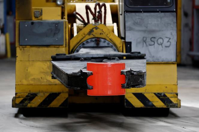 Um trabalhador manuseia uma peça brilhante de aço inoxidável durante o processo de laminação, na fundição e forjaria Safran Aircraft Engines em Gennevilliers (Hauts-de-Seine), 13 de abril de 2026