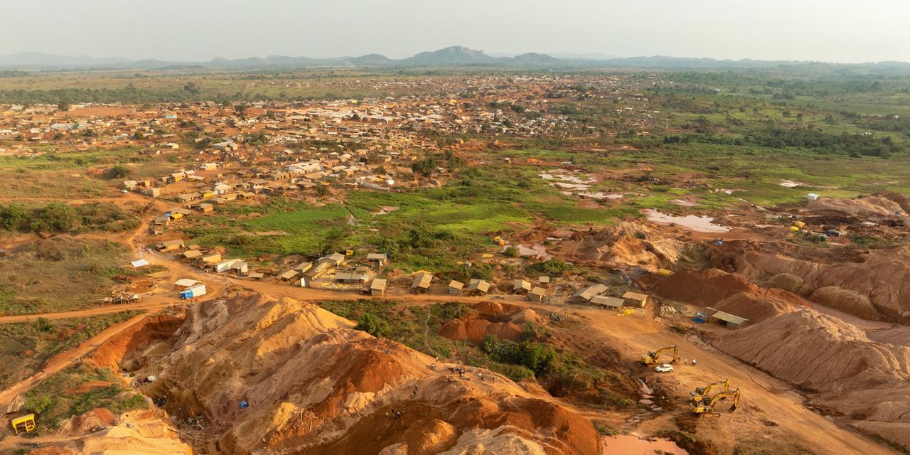 Giro, province du Haut-Uélé, RDC, 9 février 2026.

Vue aérienne d’un site d’orpaillage artisanal installé en périphérie de Giro. 

Sur le projet aurifère de Giro, ancien permis d’exploration détenu par la société australienne Giro Goldfields et récemment repris par des investisseurs chinois, certaines zones de la concession ont été laissées à l’exploitation artisanale. Ces espaces sont tolérés par les opérateurs du projet afin de limiter les tensions avec les communautés locales et les milliers de creuseurs attirés par les gisements aurifères de la région.

En République démocratique du Congo, cette pratique est fréquente autour des concessions minières industrielles. Dans le nord-est du pays, les mineurs artisanaux y exploitent les dépôts alluvionnaires d’or à l’aide d’outils rudimentaires, de pompes hydrauliques et de rampes de lavage. La hausse récente du prix de l’or a intensifié cette ruée vers les gisements du Haut-Uélé, transformant rapidement les paysages en un réseau de fosses, de talus et de bassins boueux.