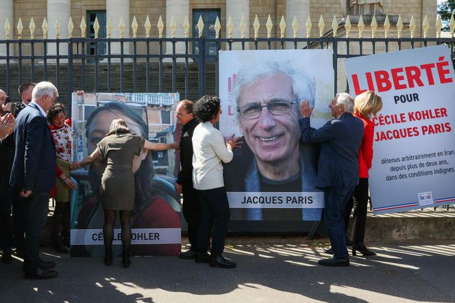 Cécile Kohler e Jacques Paris retirando os seus retratos, ajudados pelos pais de Cécile, a deputada (socialistas e afins) Ayda Hadizadeh e o presidente da Assembleia Nacional, Yaël Braun-Pivet, em frente à Assembleia Nacional, em Paris, 14 de abril de 2026.