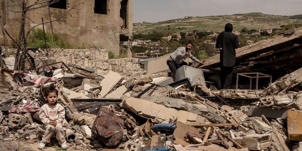 Nour et Eissa Ghazal fouillent les décombres de leur maison, alors que leur enfant, Melissa, 2 ans et demie, les attends assise, le lendemain de l'entrée en vigueur d'un cessez-le-feu, à Nabatiyé Faouqa, Liban, le 17 avril 2026.