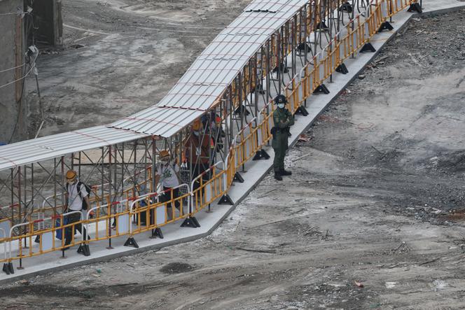 Des habitants transportent des effets personnels récupérés à Wang Fuk Court, lors de leur première visite après l’incendie meurtrier de l’année dernière, à Hong Kong (Chine), le 20 avril 2026.