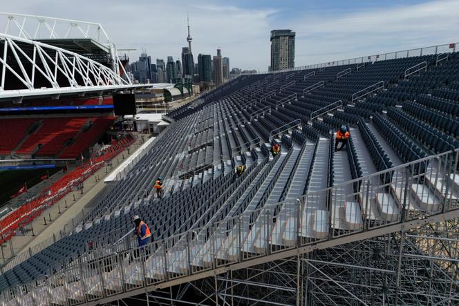 Trabalhadores instalam estandes temporários próximos aos estandes regulares no BMO Field em Toronto, Canadá, em 24 de março de 2026.