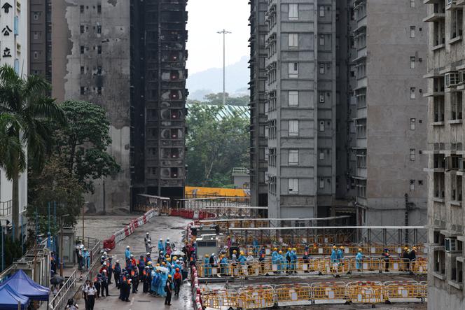 Moradores dirigem-se a um prédio em Wang Fuk Court para recolher seus pertences, em sua primeira visita desde o incêndio mortal do ano passado, em Hong Kong, China, em 20 de abril de 2026.