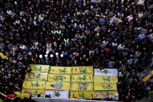 Des personnes en deuil prient près des cercueils de combattants du Hezbollah, tués lors de la guerre entre le Hezbollah et Israël, à l’occasion de leurs funérailles à Qlaylé, dans le sud du Liban, le 21 avril 2026, pendant un cessez-le-feu de dix jours entre le Liban et Israël.