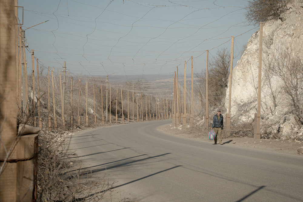Un soldat ukrainien marche sur une route recouverte de filets antidrones, à Izioum, dans l’oblast de Kharkiv, le 10 mars 2026. - IVAN SAMOILOV/AFP
