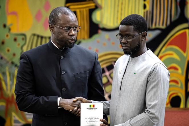 O primeiro-ministro senegalês Ousmane Sonko (à esquerda) e o presidente senegalês Bassirou Diomaye Faye durante uma cerimônia no palácio presidencial em Dakar, 16 de outubro de 2025.