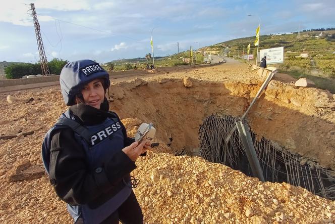 Lebanese journalist Amal Khalil, who works for the daily Al-Akhbar newspaper, reports near a destroyed bridge in Qasmiyeh, Lebanon, Sunday, March 22, 2026.