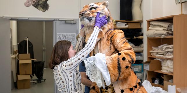 Emma Meurgey, régisseuse d’expositions, et Pierre-Jean Colacicco, assistant mannequinage et conservation, finissent de préparer le costume du tigre qui fait l’affiche de l’exposition «&nbsp;Tous en scène&nbsp;!&nbsp;» (costume de Jean-Marc Stehlé pour le rôle du Tigre dans «&nbsp;La Flûte enchantée&nbsp;», de Mozart, Opéra de Paris, 2000), au CNCS à Moulins, le 14&nbsp;avril&nbsp;2026. 