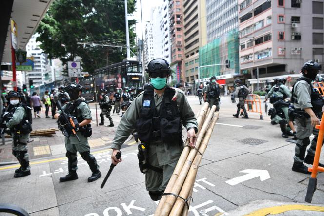 Membro da polícia de choque durante a dispersão de manifestantes que participavam numa manifestação pró-democracia contra uma proposta de lei de segurança, em Hong Kong, em 24 de maio de 2020.