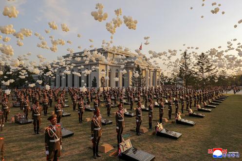 Se lanzan globos mientras los soldados se encuentran cerca de piedras conmemorativas durante la inauguración de un monumento a los soldados norcoreanos asesinados en Ucrania, en Pyongyang, el 26 de abril de 2026.