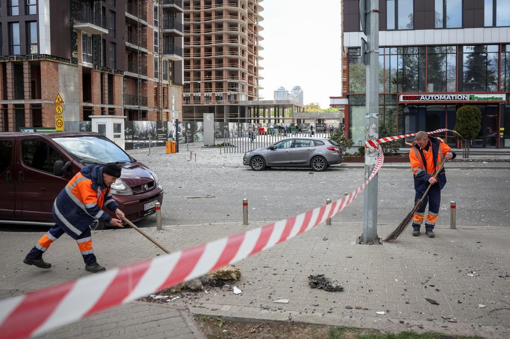 Des agents municipaux sur le site d’une frappe de drone russe, à Kiev, le 28 avril 2026. - GLEB GARANICH/REUTERS