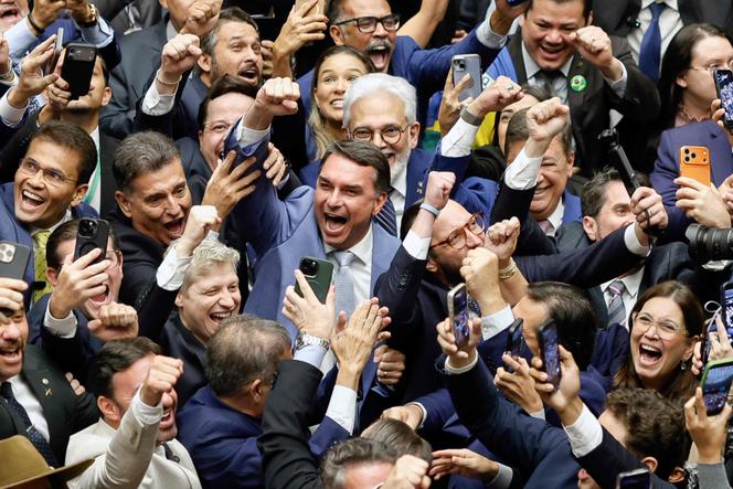 O senador Flavio Bolsonaro (filho mais velho do ex-presidente Jair Bolsonaro, centro) comemora a votação que anula o veto do presidente Lula a um projeto de lei para reduzir as penas dos condenados por tentativa de golpe de Estado, no Parlamento em Brasília, 30 de abril de 2026. 