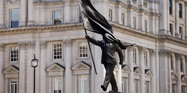 À Londres, le 30&nbsp;avril 2026, se dresse une statue de l’artiste de rue britannique Banksy représentant une personne descendant de son socle, le visage dissimulé par un drapeau. (REUTERS/Jack Taylor)