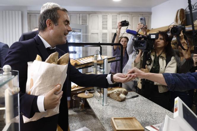 France's Prime Minister Sébastien Lecornu buys during a visit to a bakery to mark Labor Day, Saint-Julien-Chapteuil, south-central France, May 1, 2026.