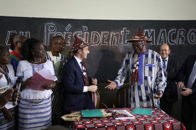Emmanuel Macron et le président du Burkina Faso, Roch Marc Christian Kaboré (2ᵉ à droite), portent des chapeaux traditionnels lors de la visite de l’école Lagm Taaba, dans le cadre de la première tournée africaine du président français, à Ouagadougou, le 28 novembre 2017.