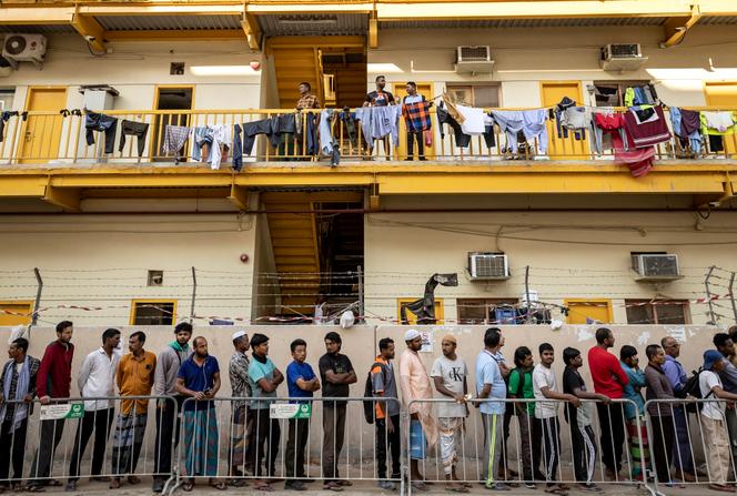 Des ouvriers pendant une distribution de repas, à Dubaï, le 18 mars 2025.