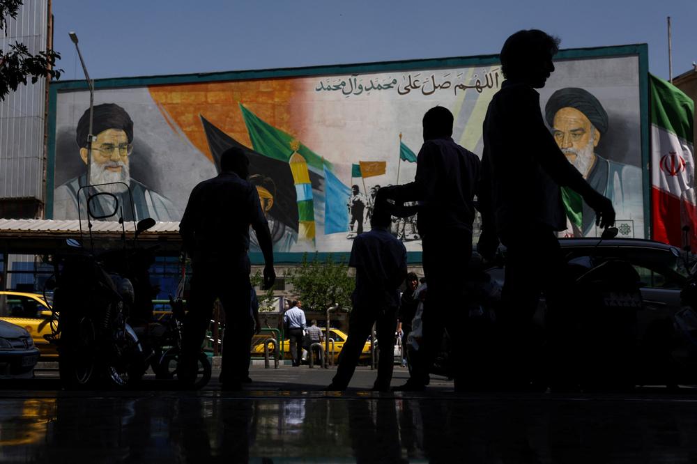 Devant une fresque représentant Rouhollah Khomeini et Ali Khamenei, à Téhéran, le 12 mai 2026. - MAJID ASGARIPOUR/WANA VIA REUTERS