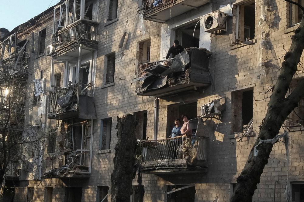 Des habitants dans leur immeuble endommagé par un missile russe à Dnipro (Ukraine), le 18 mai 2026. - REUTERS